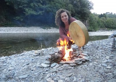 Marion et son tambour devant un feu au bord de la rivière